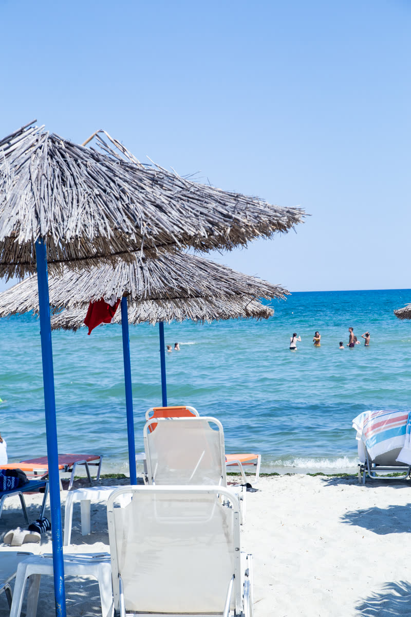 Ομπρέλα και ξαπλώστρες μπροστά στο κύμα