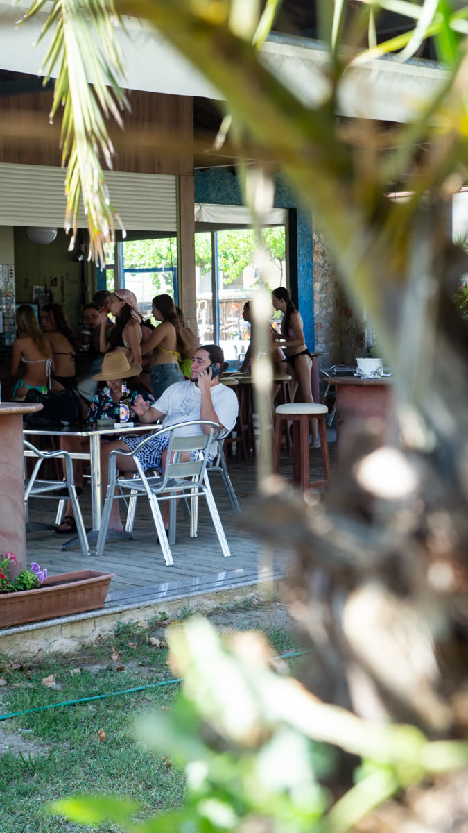 Κόσμος στα τραπέζια του beach bar, στη σκιά